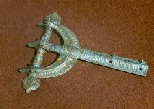 Bronze arched brooch with poppy head shaped ends from 8th–9th c. Photograph by K. Demereckas