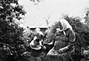 Marė Reizgienė su vaikaičiu  Albertu sode. Apie 1960 m. Fotografas nežinomas / Iš I. E. Kuzmienės šeimos albumo